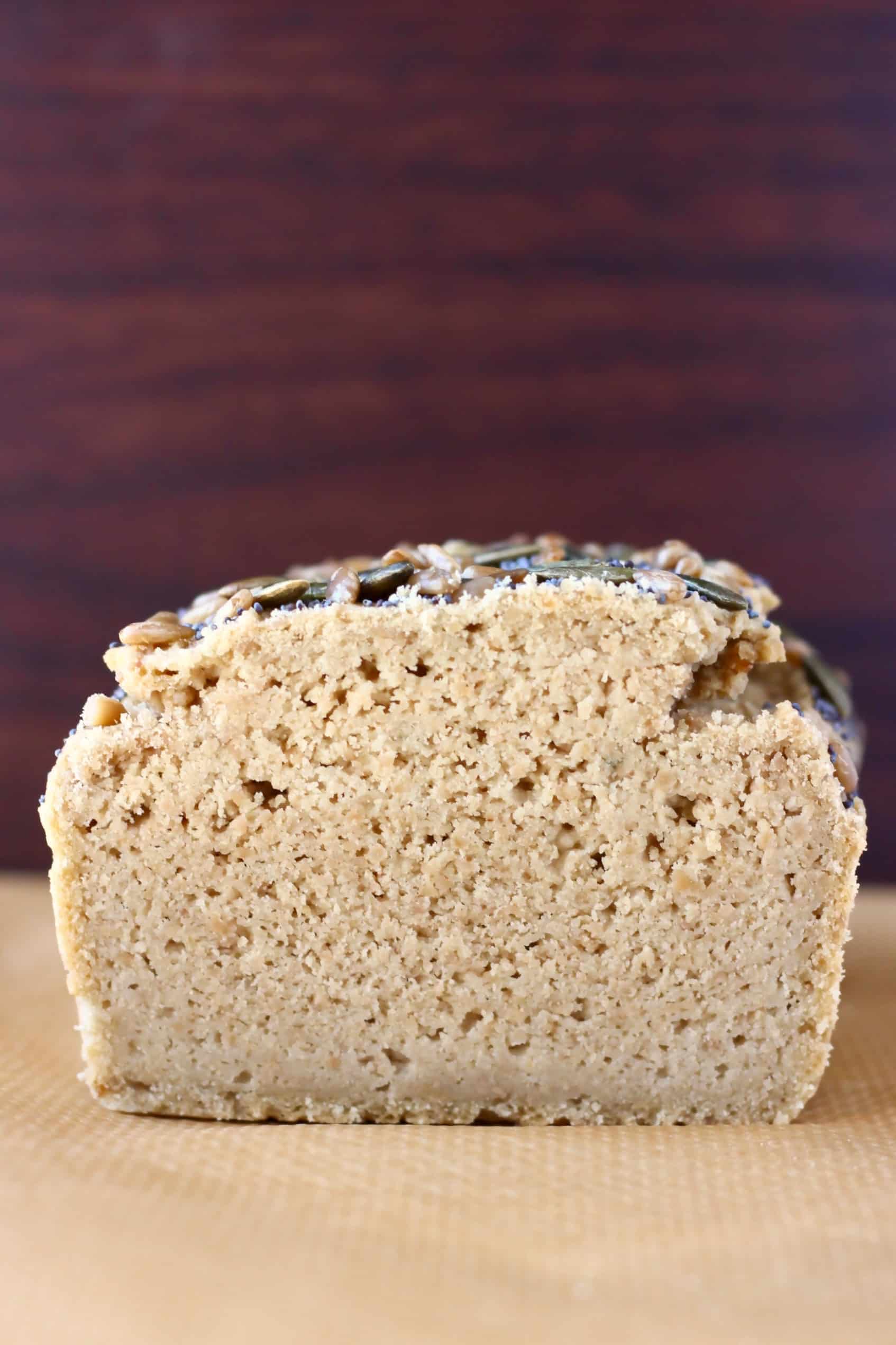 A sliced loaf of sunflower seed bread on a sheet of baking paper