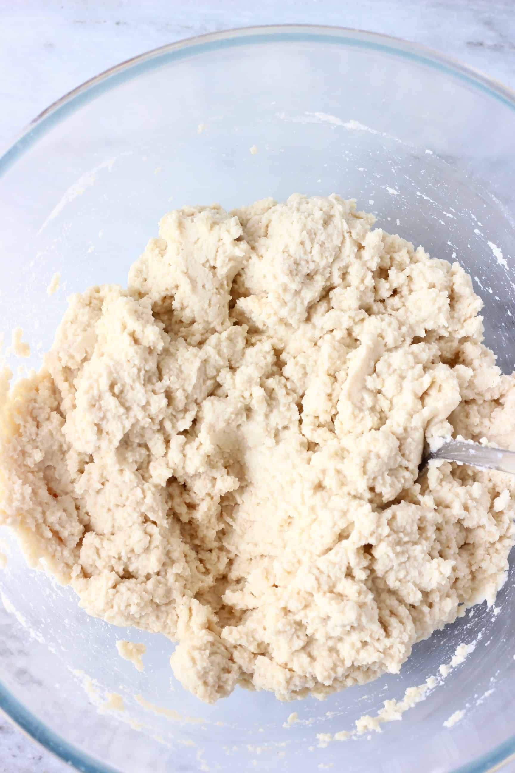 Raw gluten-free rice bread batter in a glass mixing bowl 