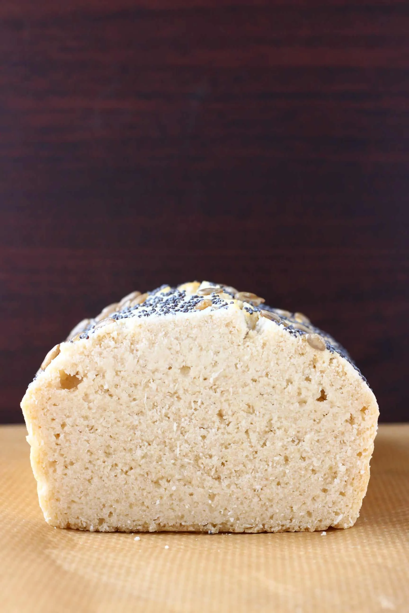 A sliced loaf of gluten-free rice bread on a sheet of brown baking paper 