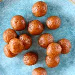 Several brown round vegan energy balls on a plate