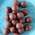 A pile of chocolate vegan protein balls on a blue plate