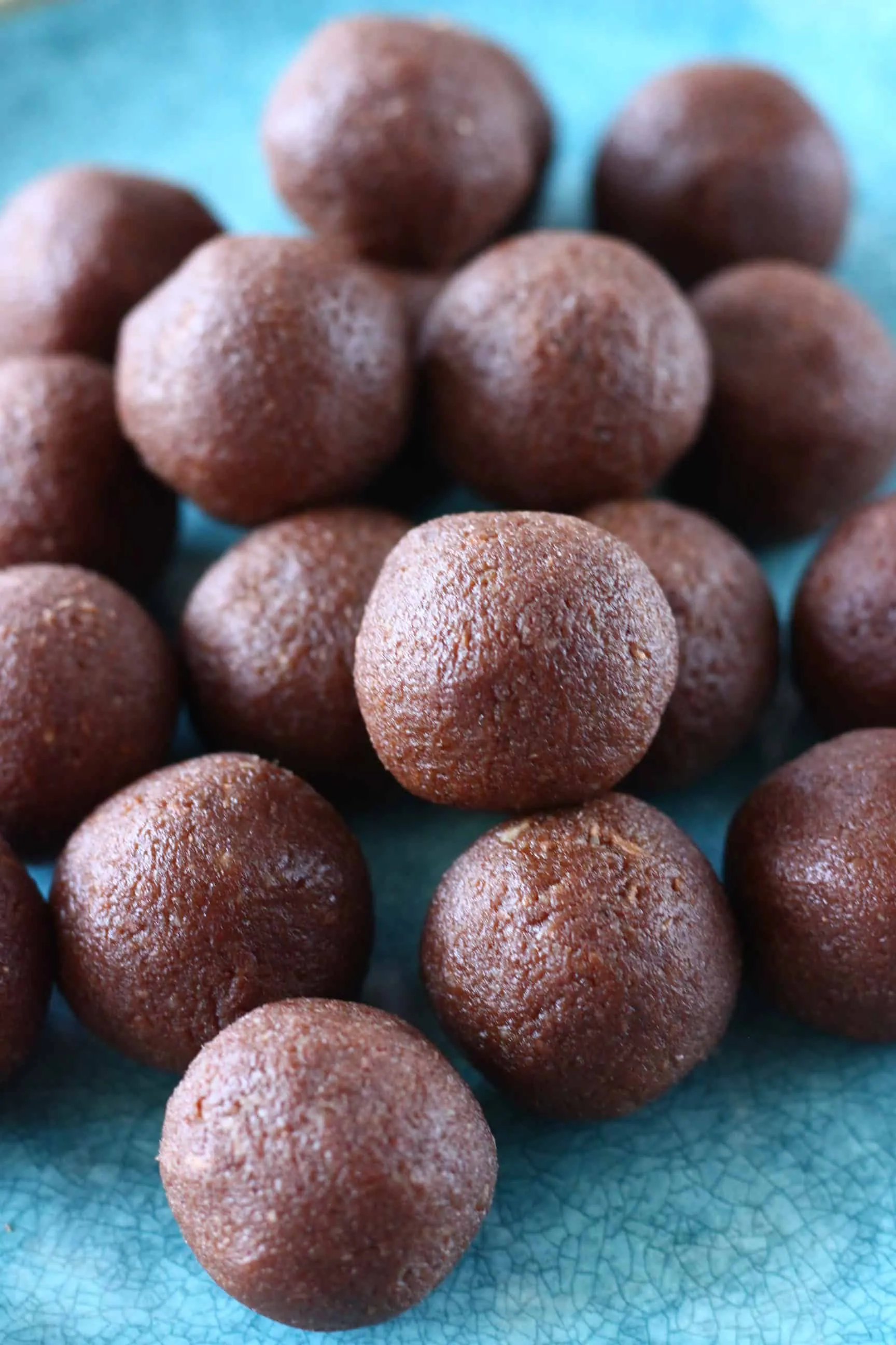 A pile of chocolate vegan protein balls on a blue plate