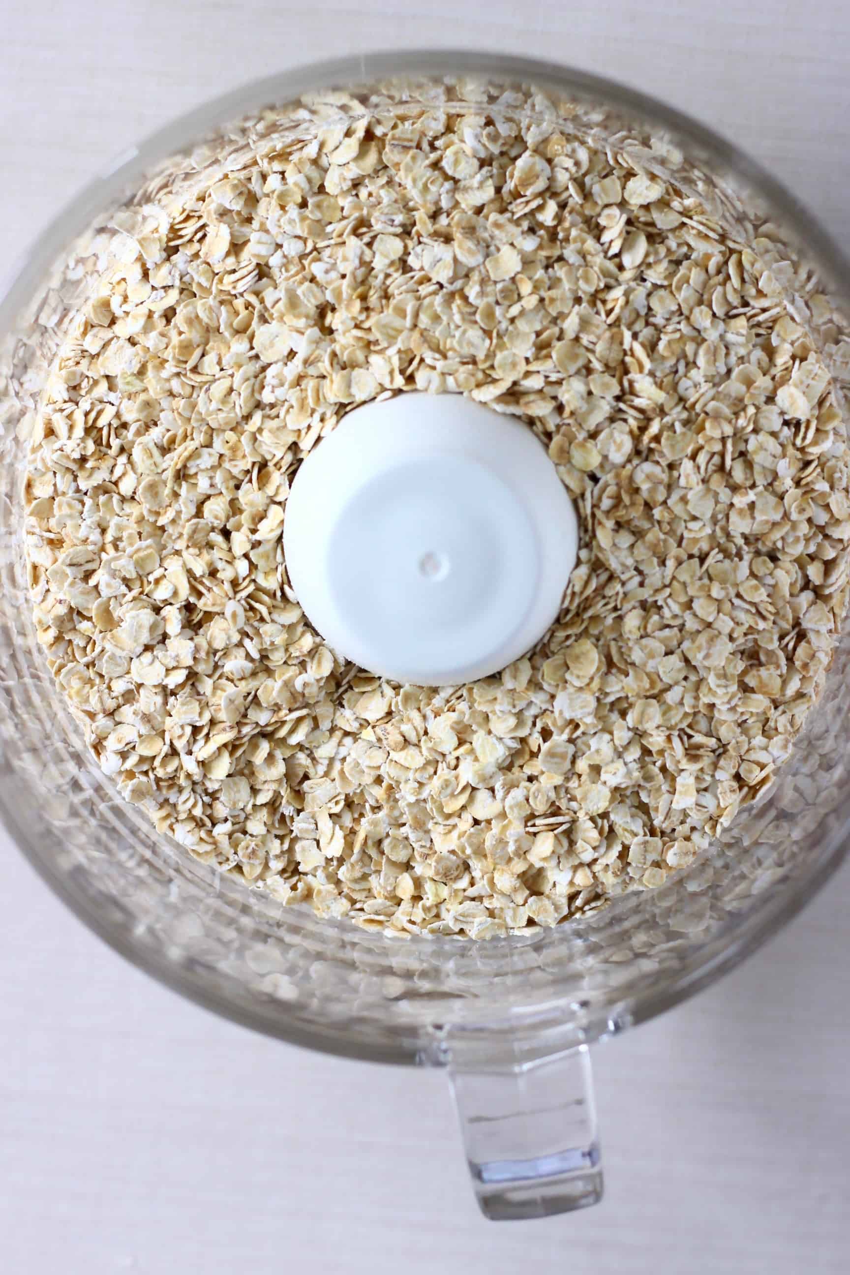 Oats in a food processor against a white background