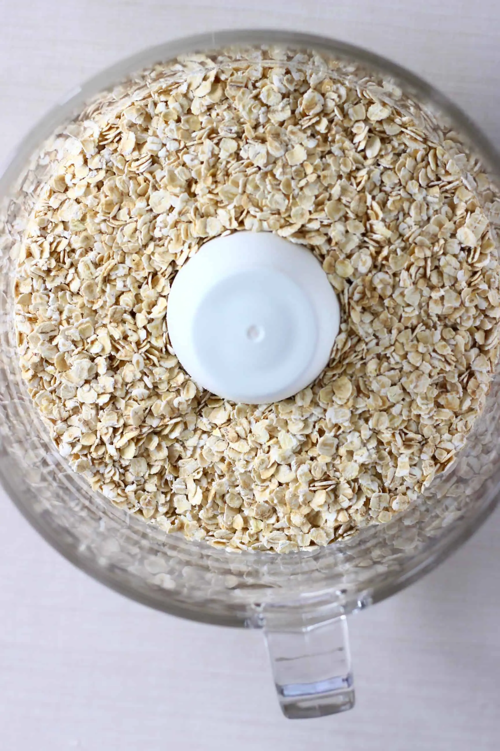 Oats in a food processor against a white background