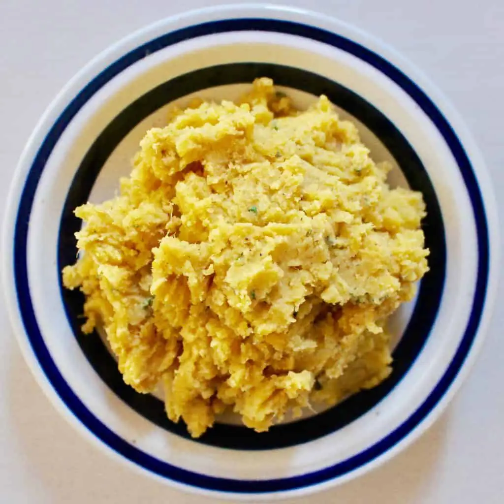 Photo of sweet potato hummus in a white bowl with a dark blue rim