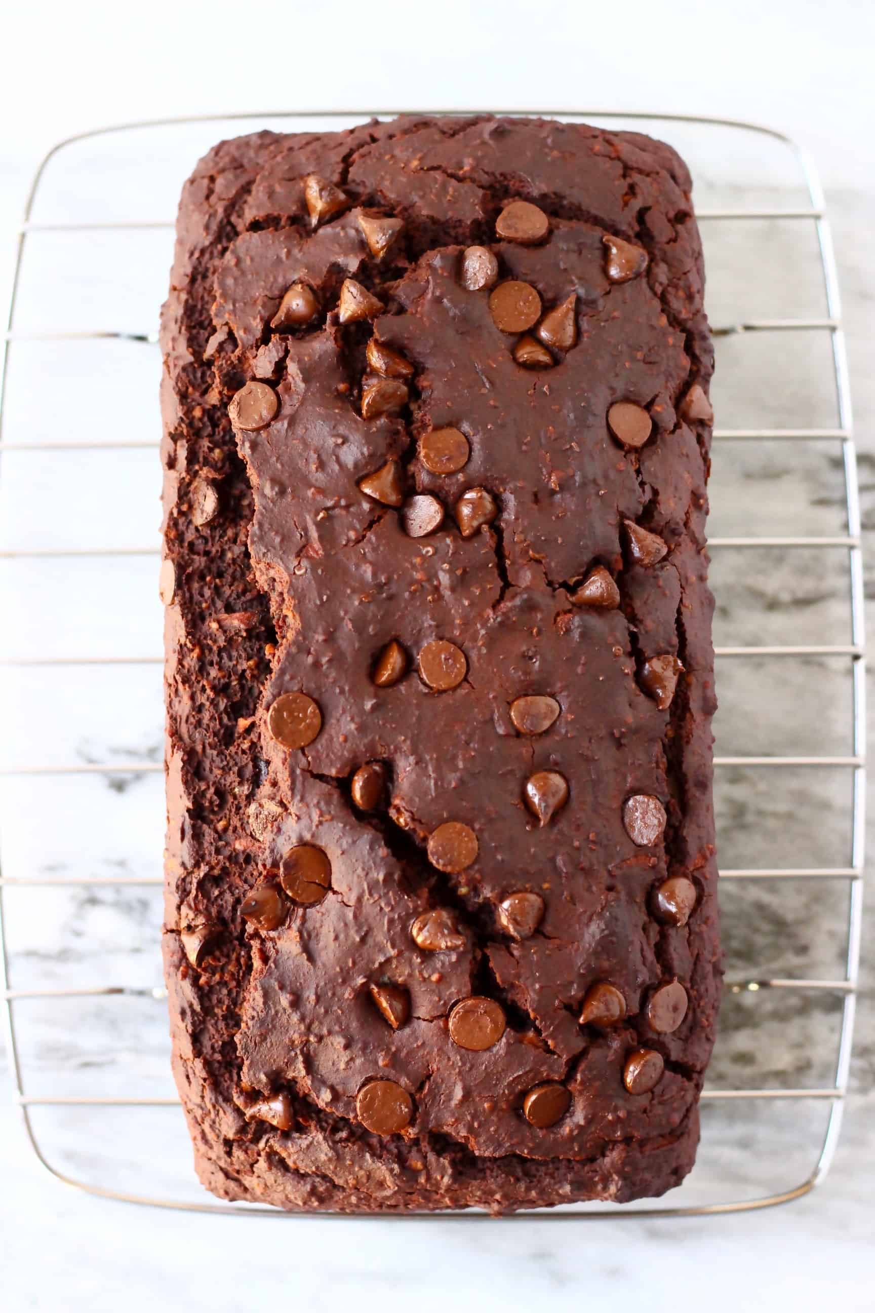 A loaf of gluten-free vegan chocolate zucchini bread on a wire rack 