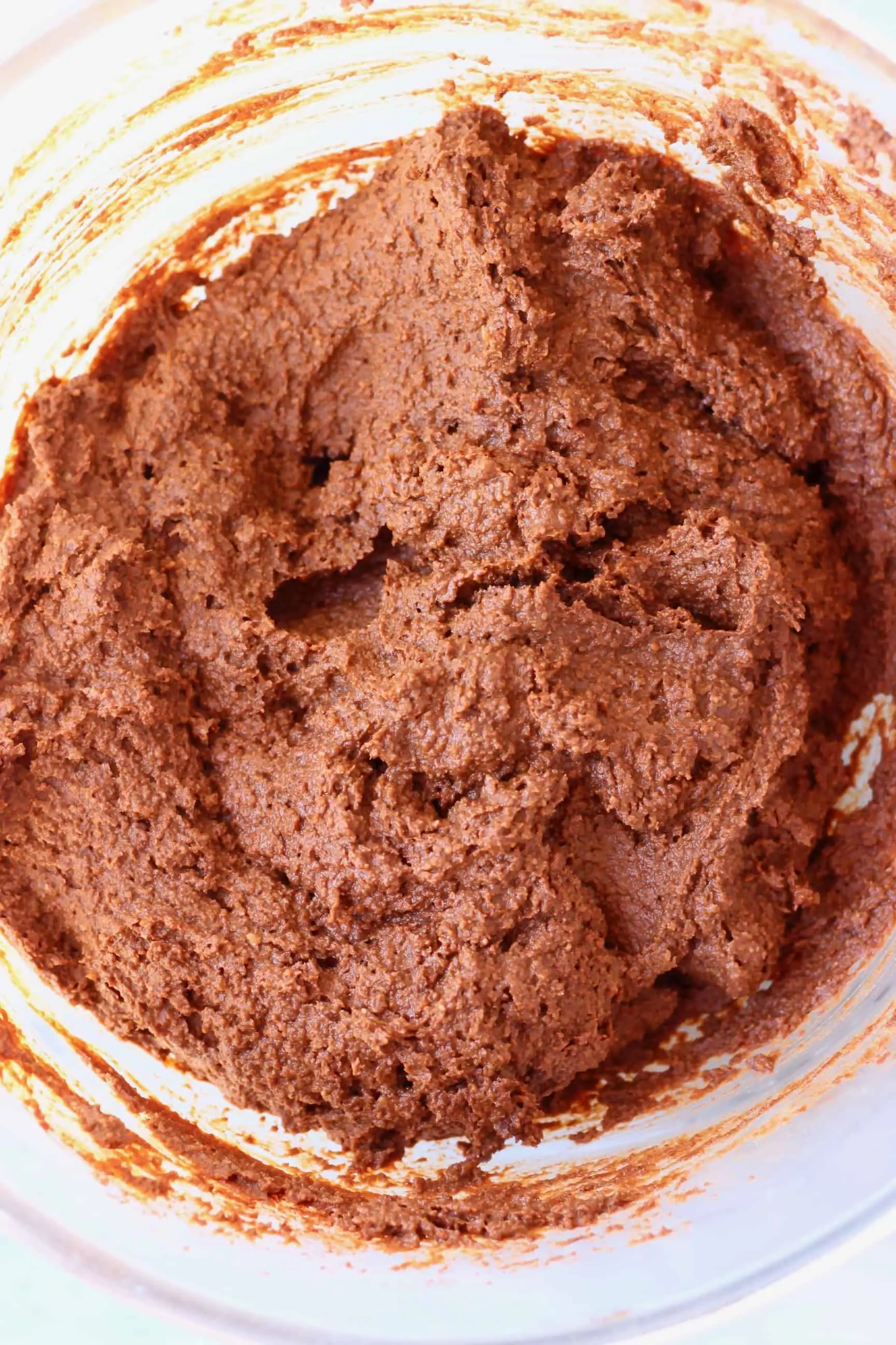 Raw pumpkin brownie batter in a glass mixing bowl