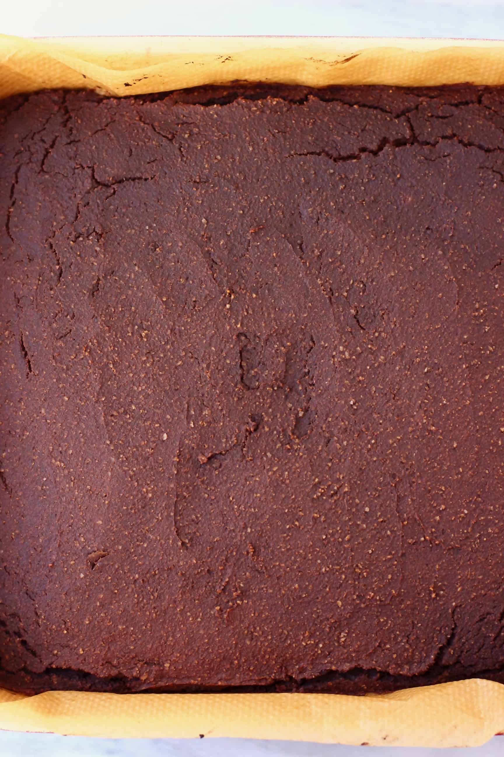 A square baking tray of pumpkin brownies against a marble background