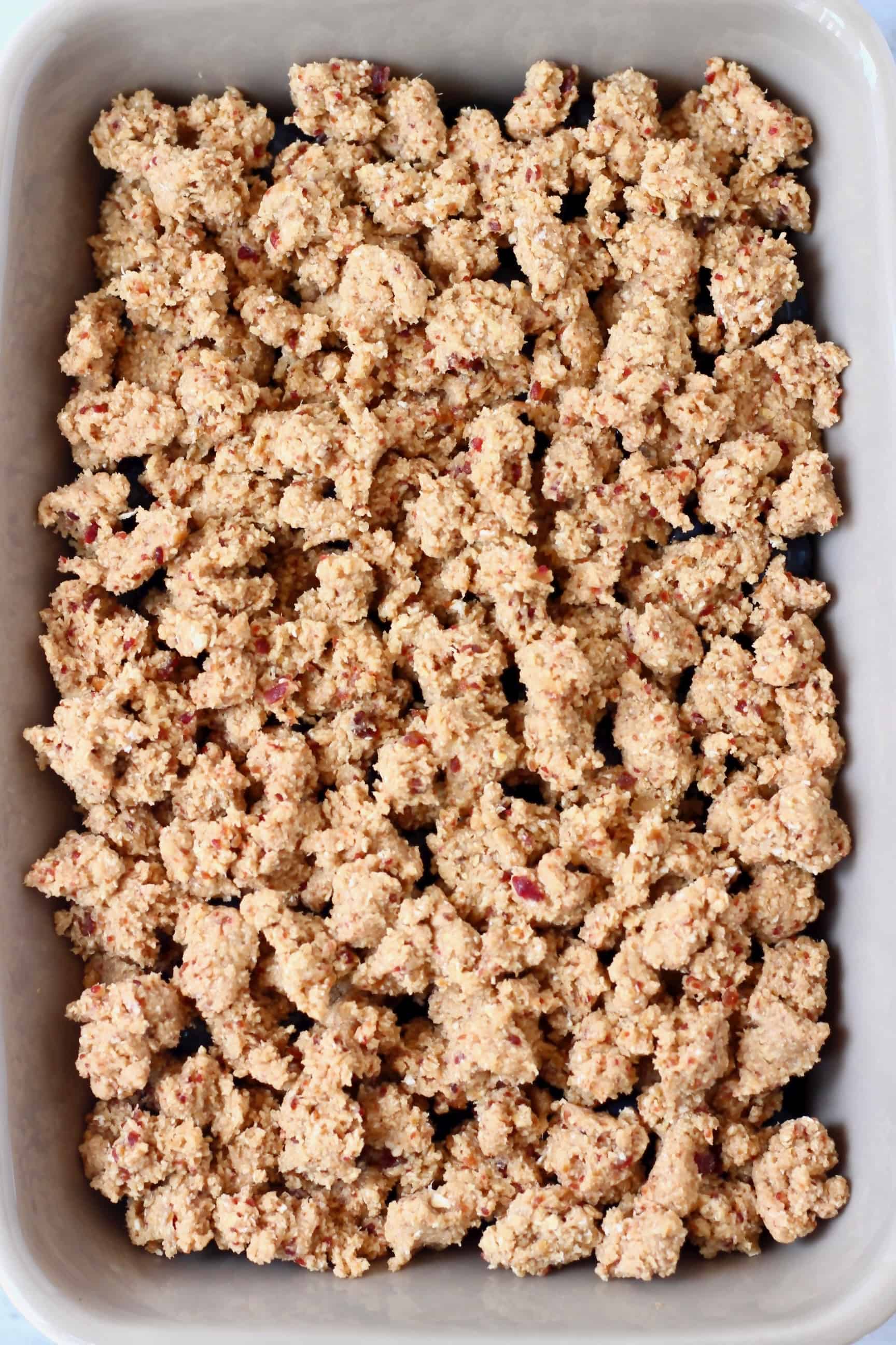 Raw blueberry crisp in a grey rectangular baking