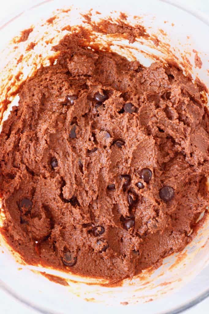 Raw chocolate pumpkin bread batter with chocolate chips in a glass mixing bowl