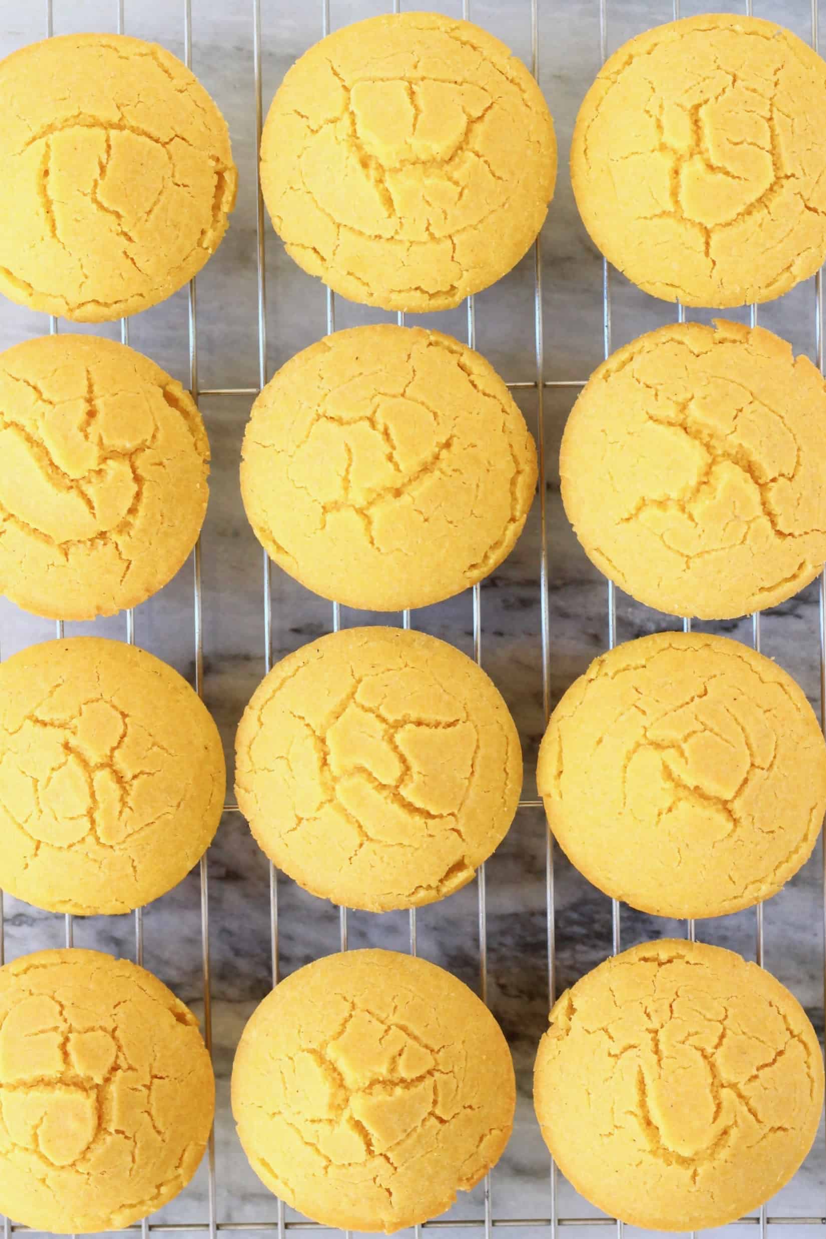 Twelve gluten-free vegan cornbread muffins on a wire rack against a marble background