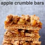 A stack of three apple crumble bars on a marble slab against a grey background
