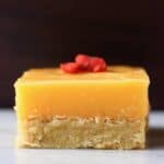 A gluten-free vegan lemon bar topped with goji berries