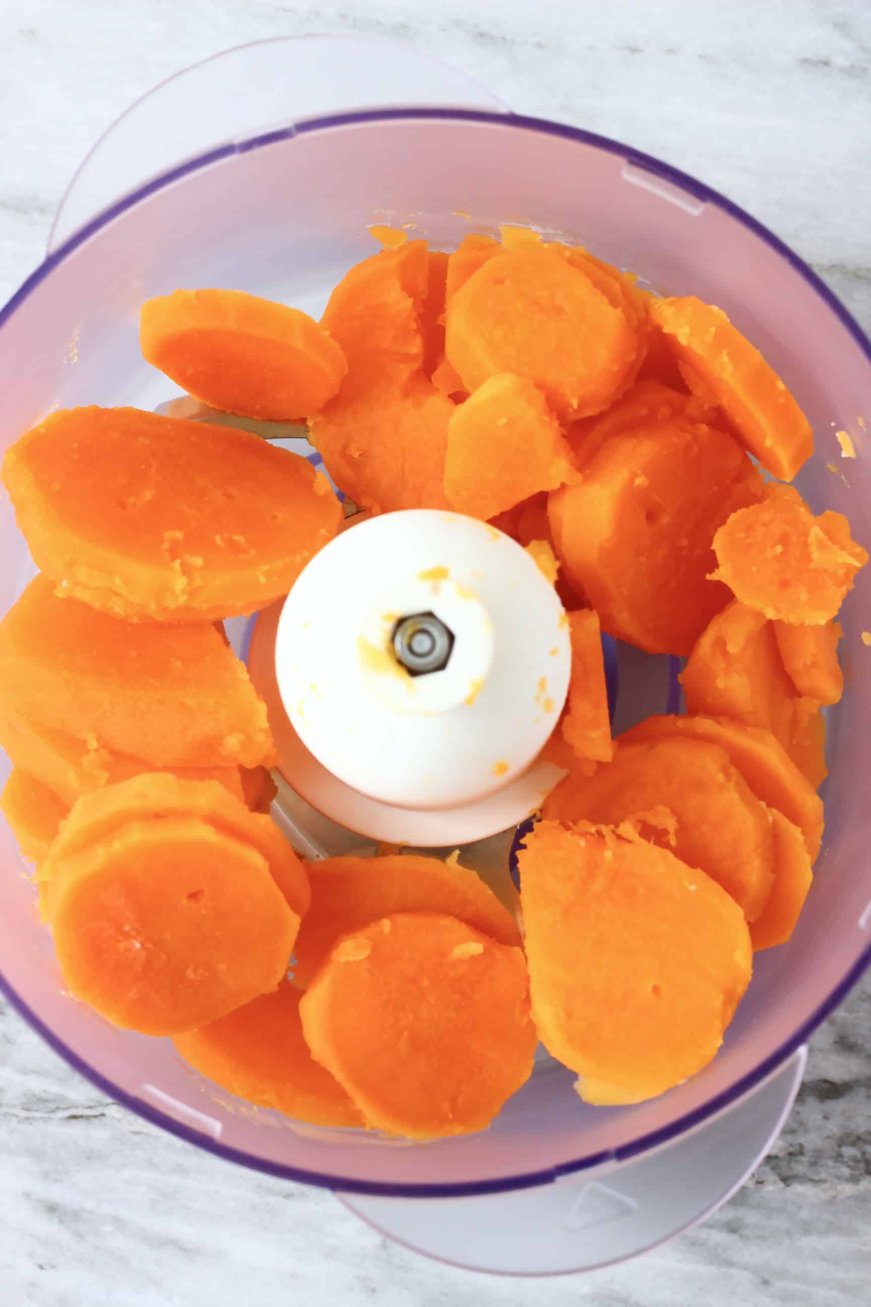 Sliced cooked sweet potatoes in a food processor