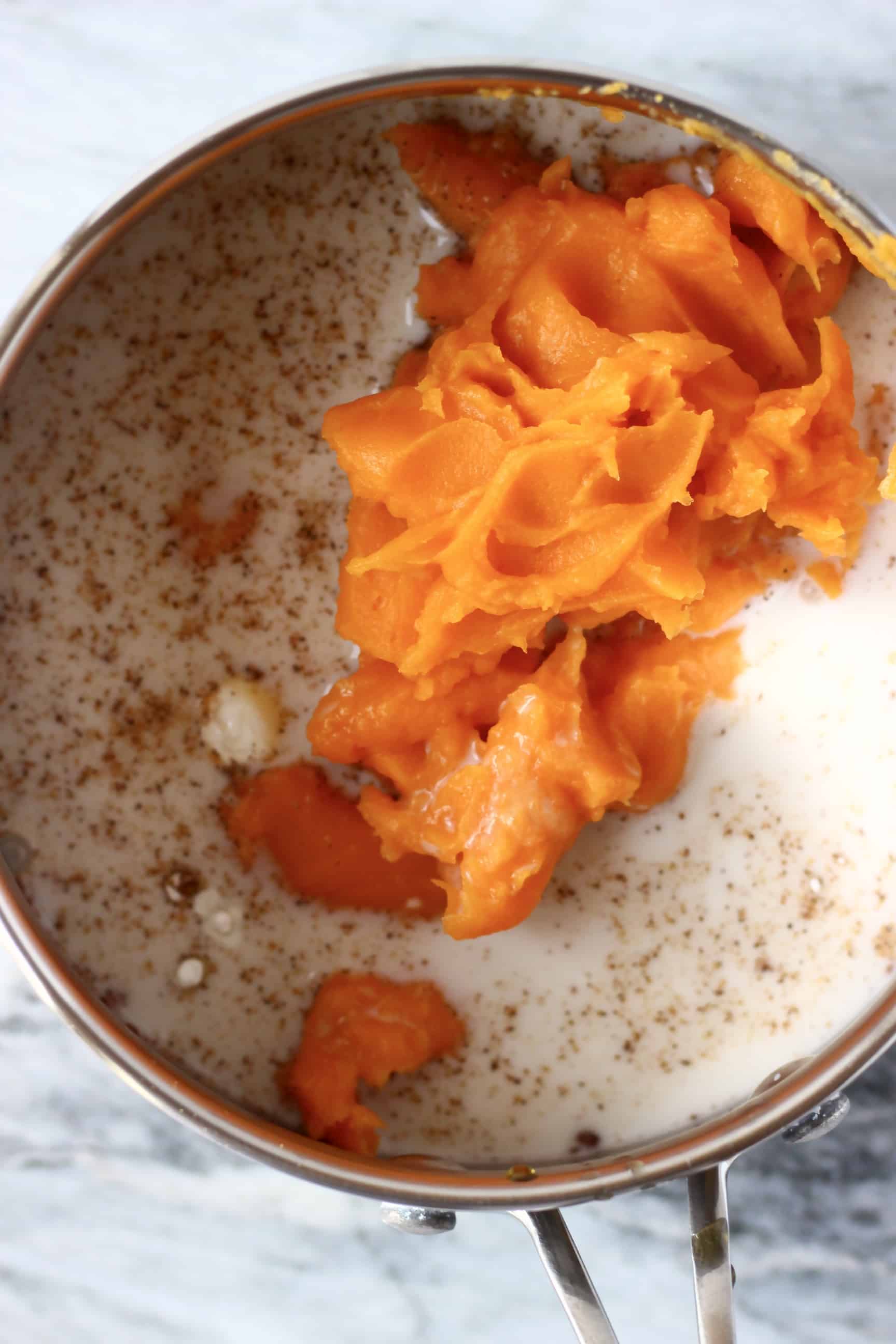 Sweet potato purée, milk and spices in a silver pan