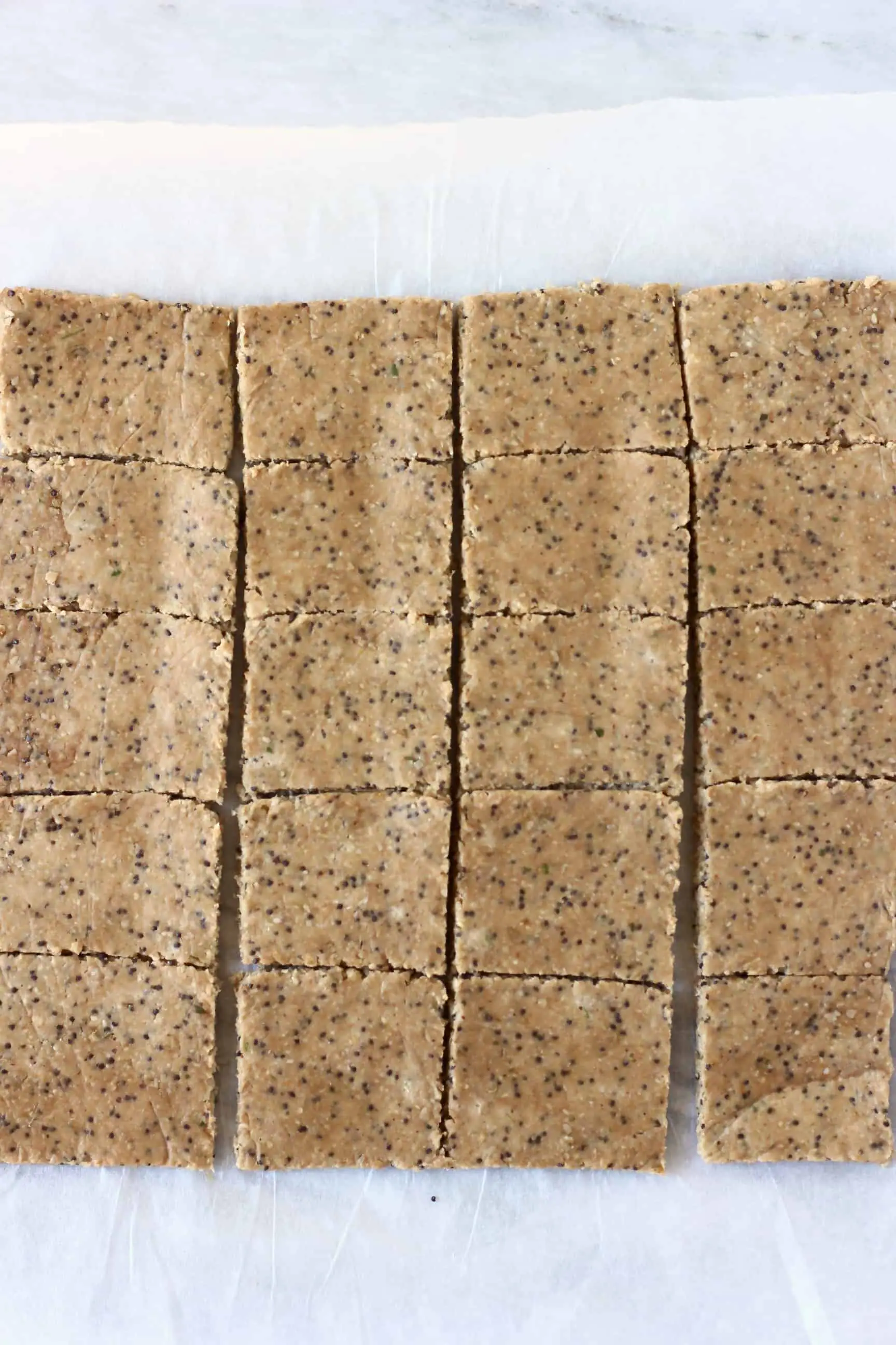 Squares of raw gluten-free vegan cracker mixture on a sheet of baking paper