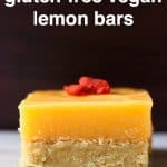 A lemon bar topped with goji berries on a marble slab