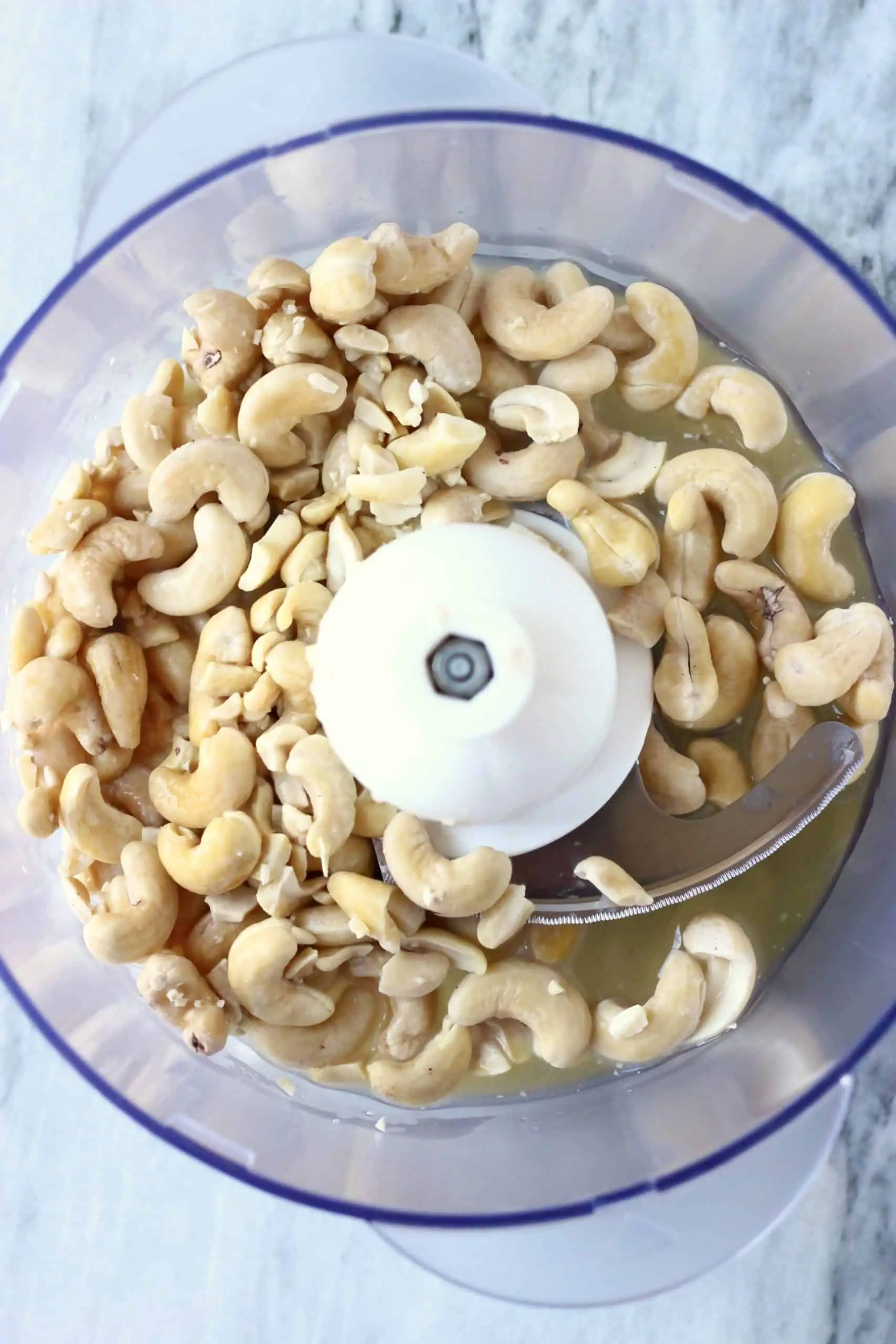 Cashew nuts, orange juice and maple syrup in a food processor 