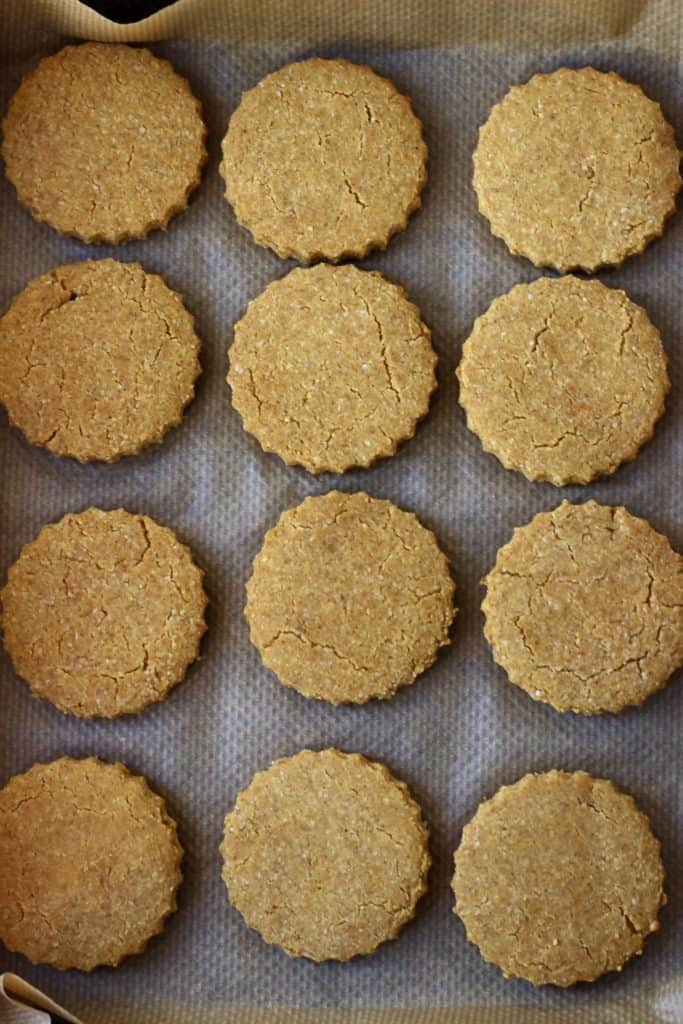Twelve gluten-free vegan pumpkin sugar cookies on a baking tray