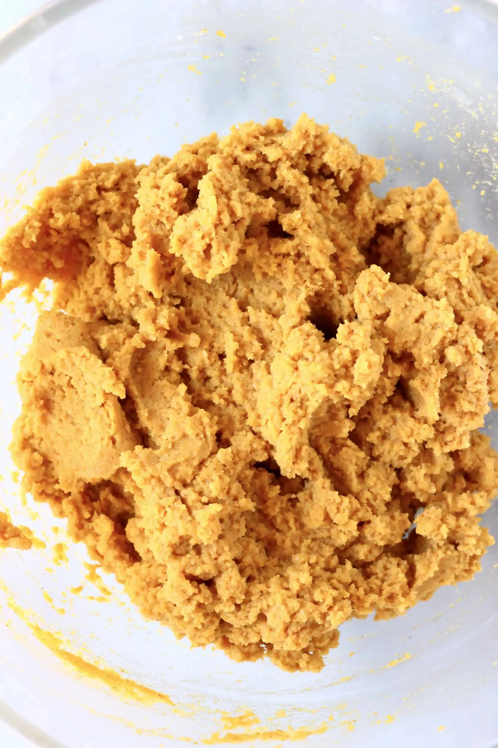 Raw pumpkin scone dough in a glass mixing bowl
