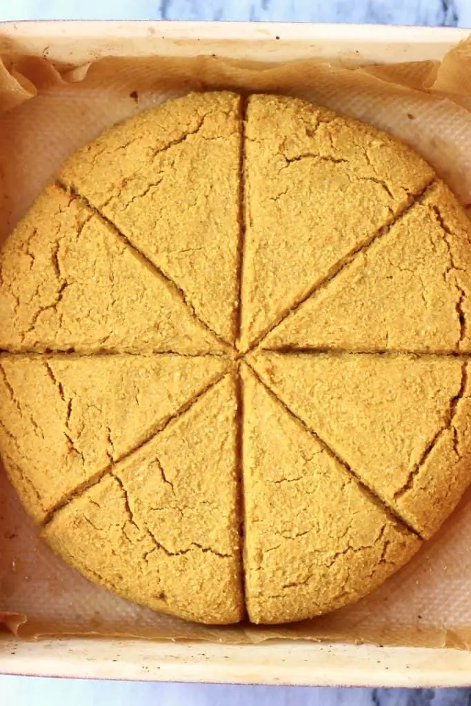 A circle of pumpkin scones in a baking tray cut into eight