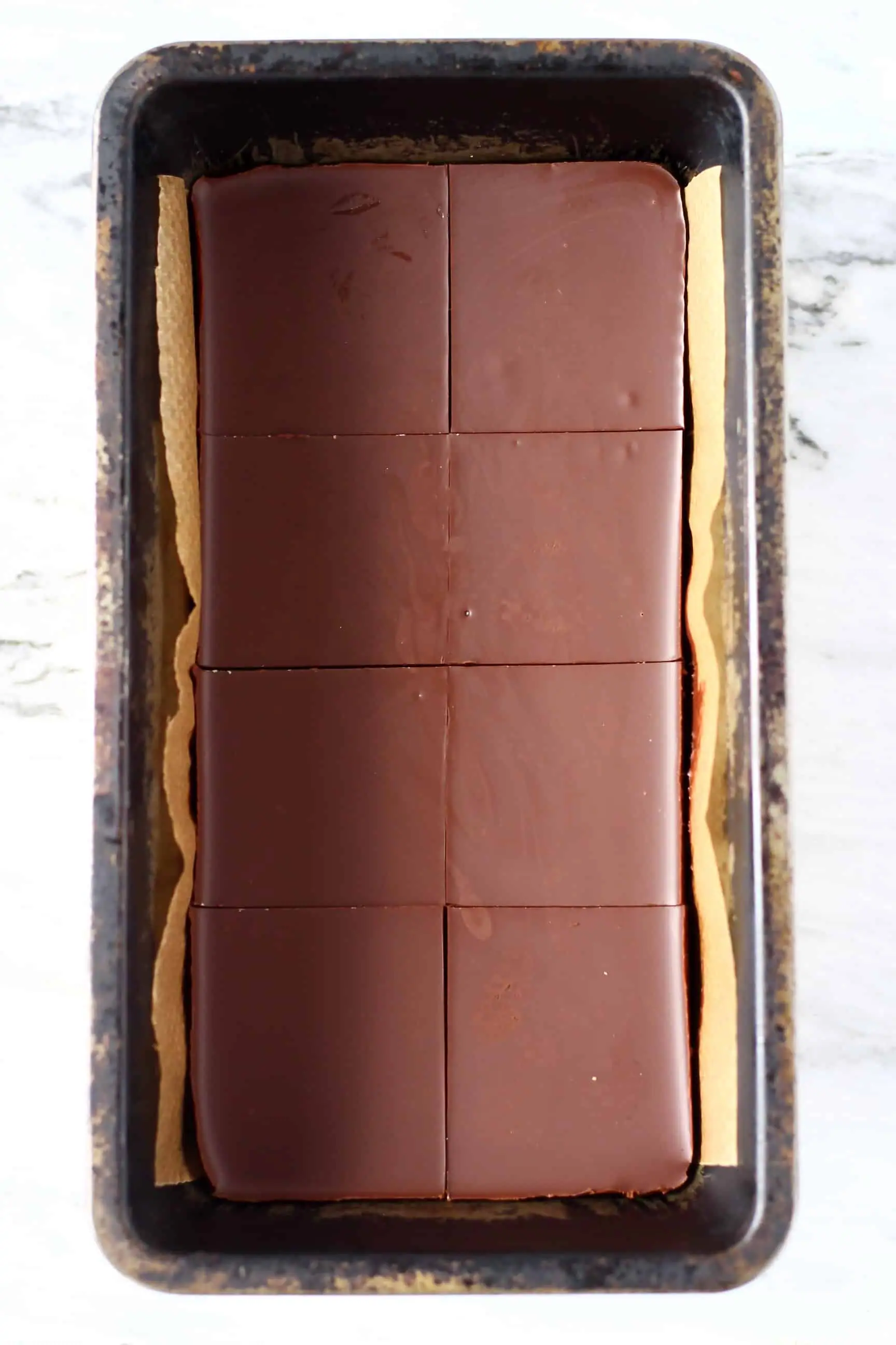 Chocolate peanut butter bars in a loaf tin cut into eight squares