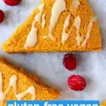 Three triangular pumpkin scones drizzled with white icing on a marble background