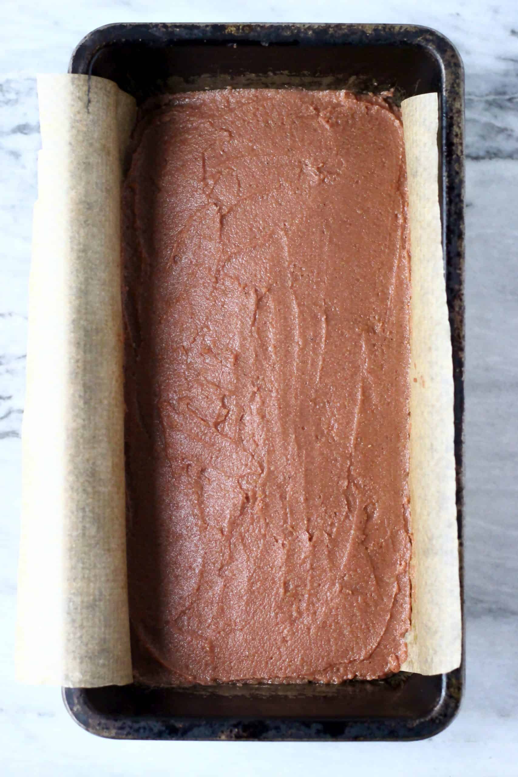 Raw gluten-free vegan gingerbread loaf cake batter in a loaf tin lined with baking paper