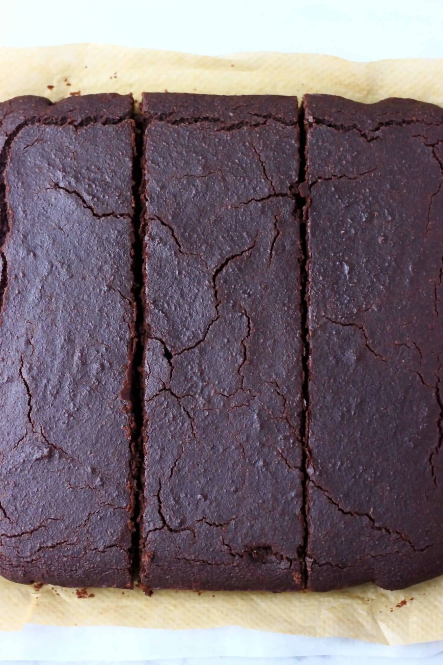 Square vegan chocolate sponge cake cut into three