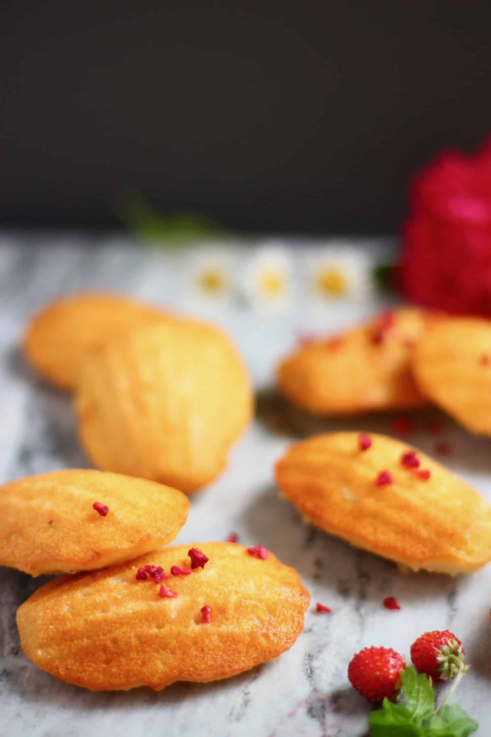 Seven madeleines on a marble background decorated with flowers