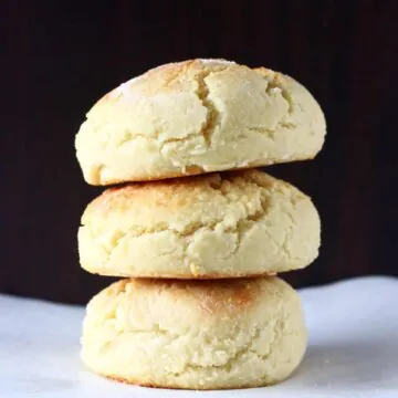 Three gluten-free vegan biscuits on top of each other against a dark brown background