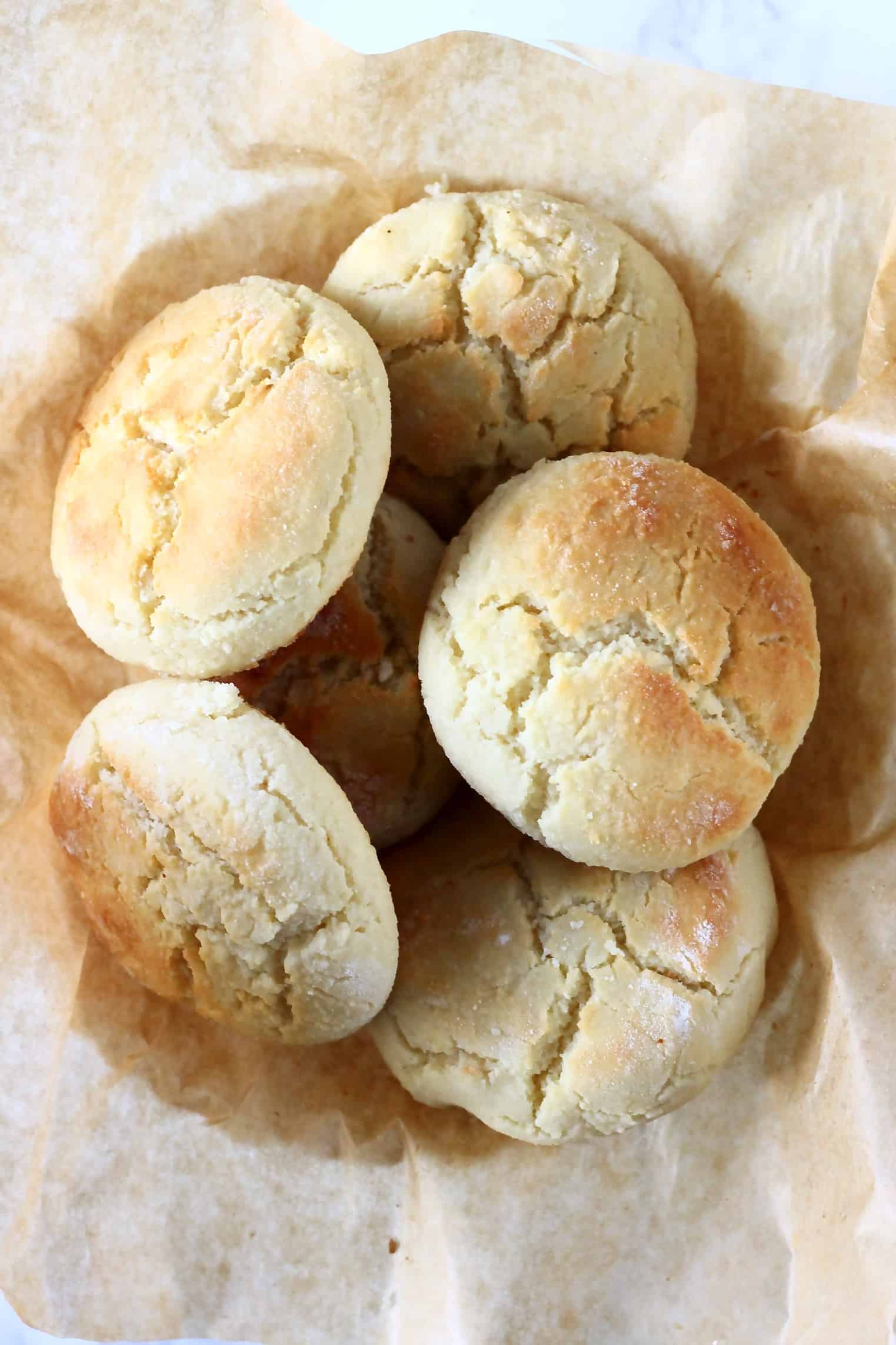 Six gluten-free vegan biscuits in a bowl lined with brown baking paper