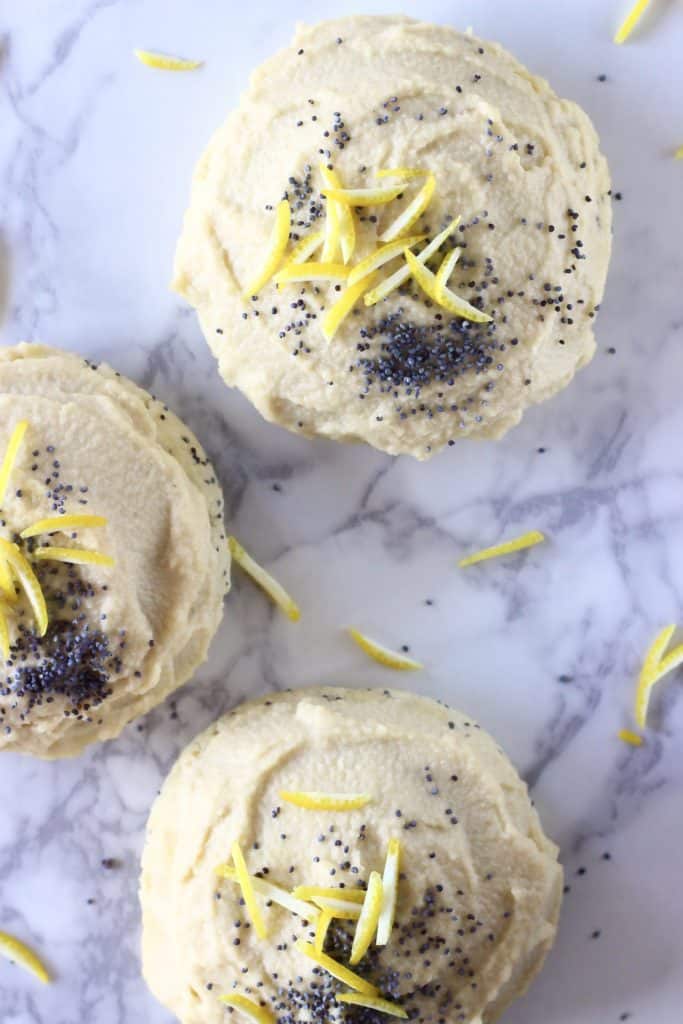 Lemon poppy seed cookies with frosting against a marble background