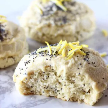 Lemon poppy seed cookies with frosting with a bite taken out of one