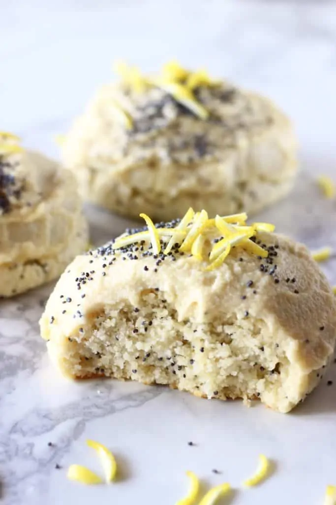 Lemon poppy seed cookies with frosting with a bite taken out of one