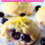 Three lemon blueberry cookies with frosting and a bite taken out of one