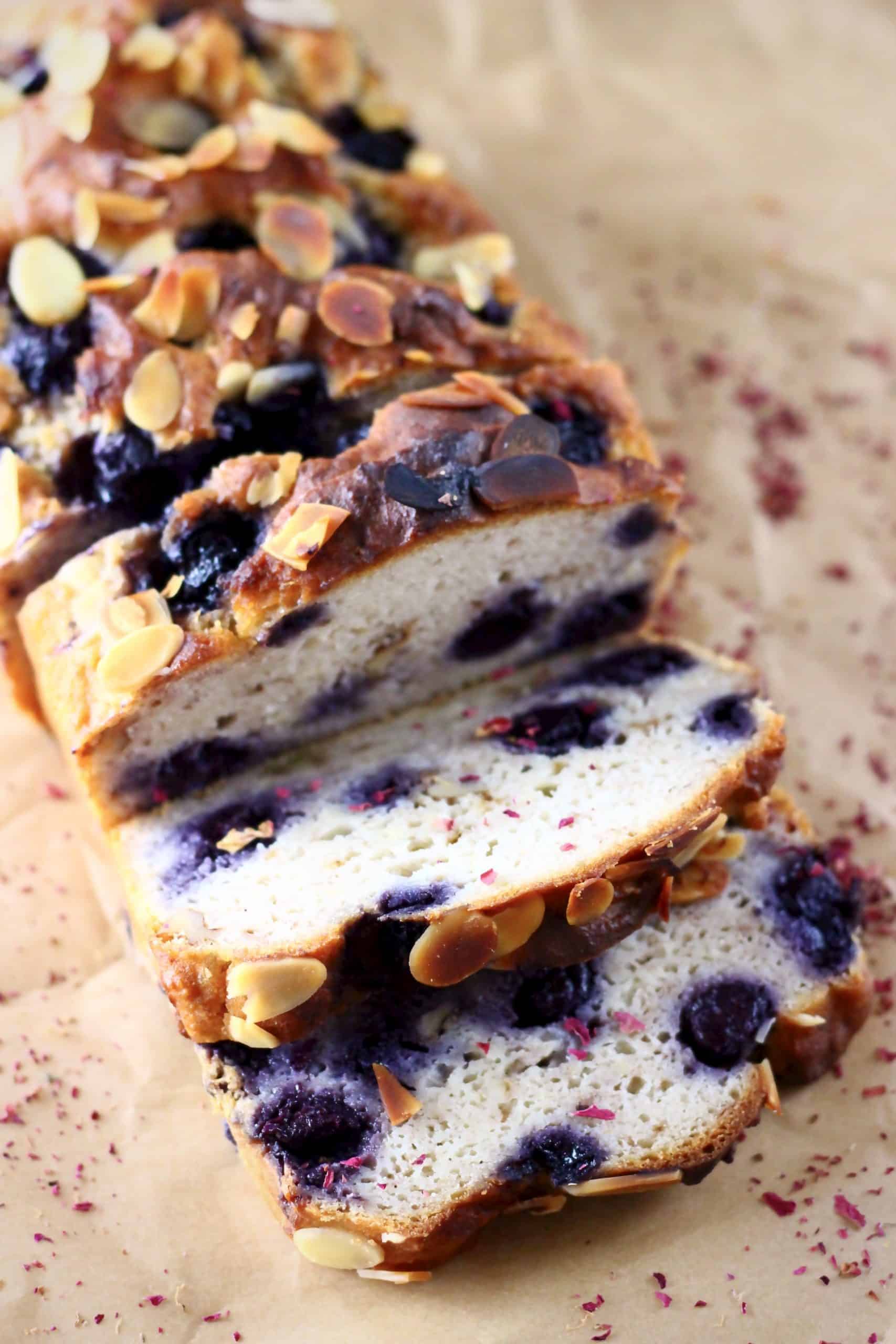 A loaf of blueberry banana bread with three slices next to it