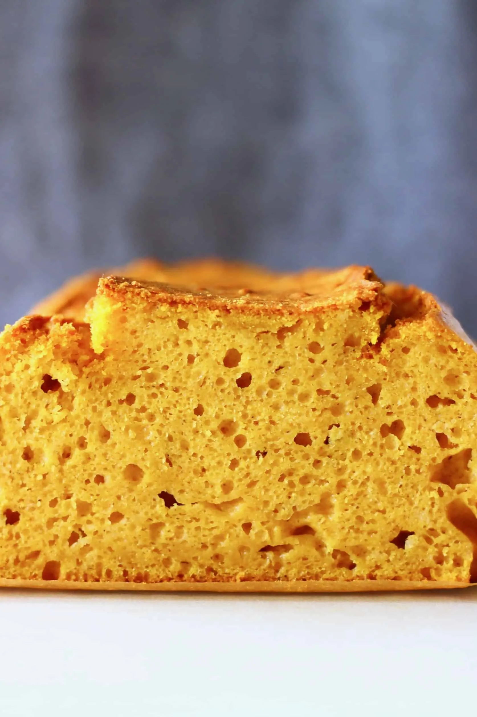 A loaf of pumpkin bread against a grey background