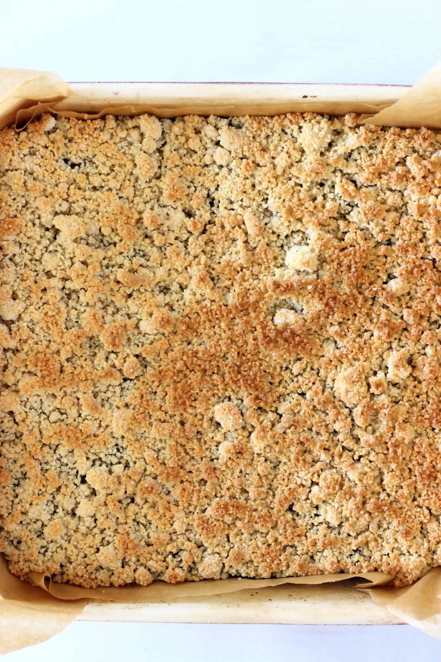 Baked gluten-free vegan blueberry crumble bars in a square baking tin