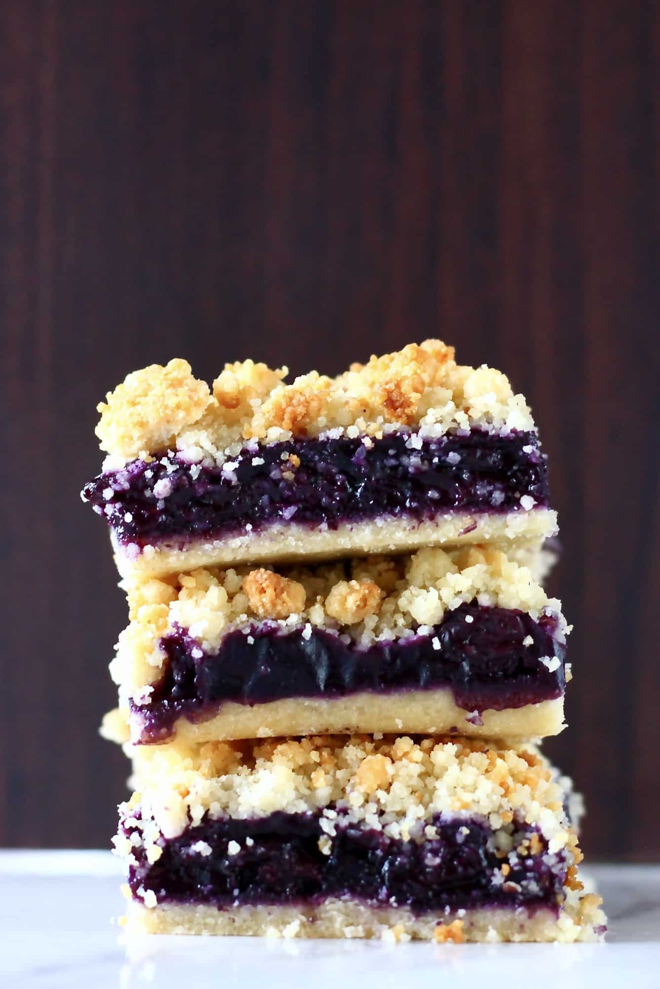 Three gluten-free vegan blueberry crumble bars stacked on top of each other