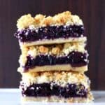 Three gluten-free vegan blueberry crumble bars stacked on top of each other