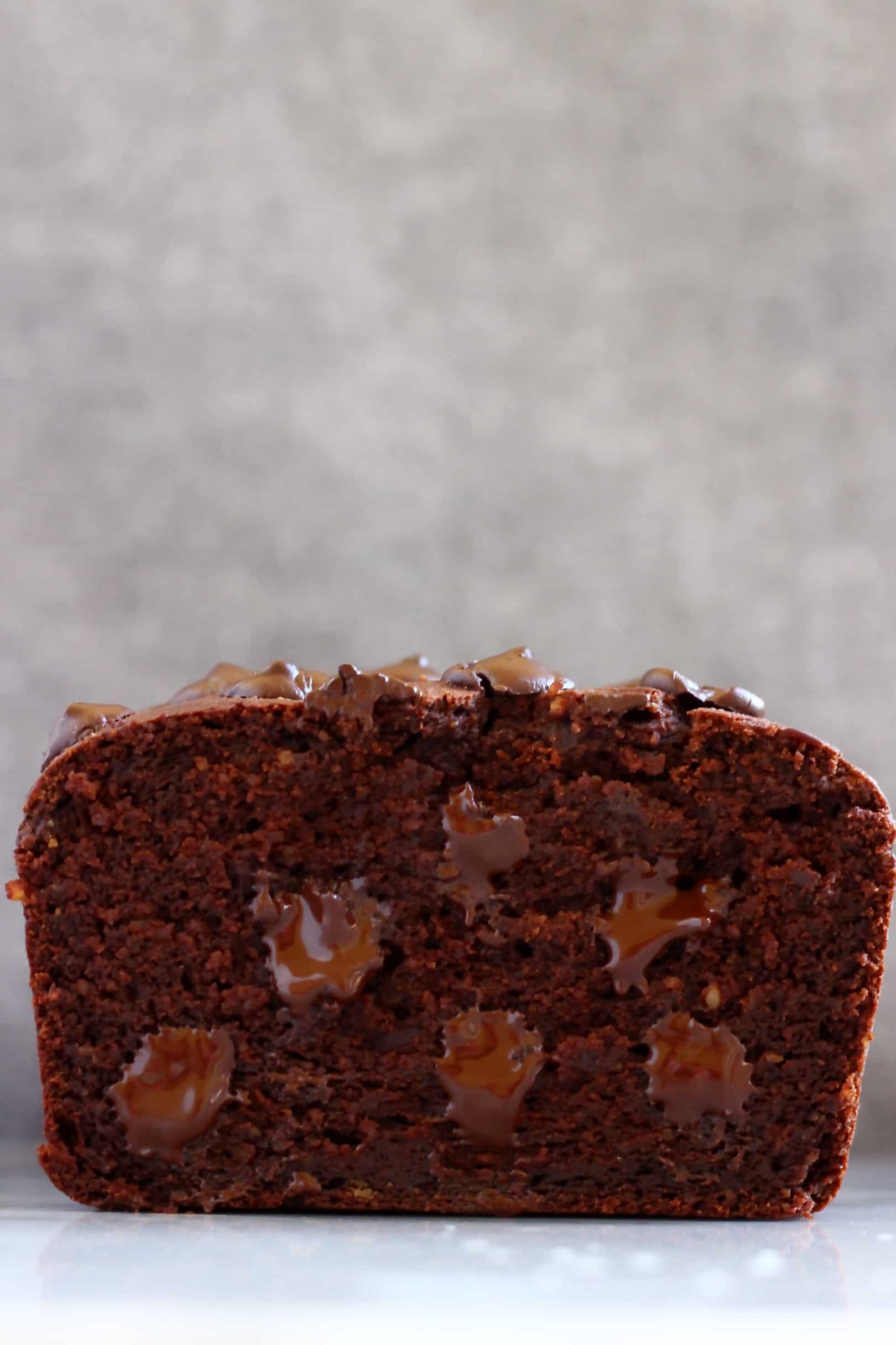 Sliced sweet potato chocolate loaf cake with chocolate chips against a grey background