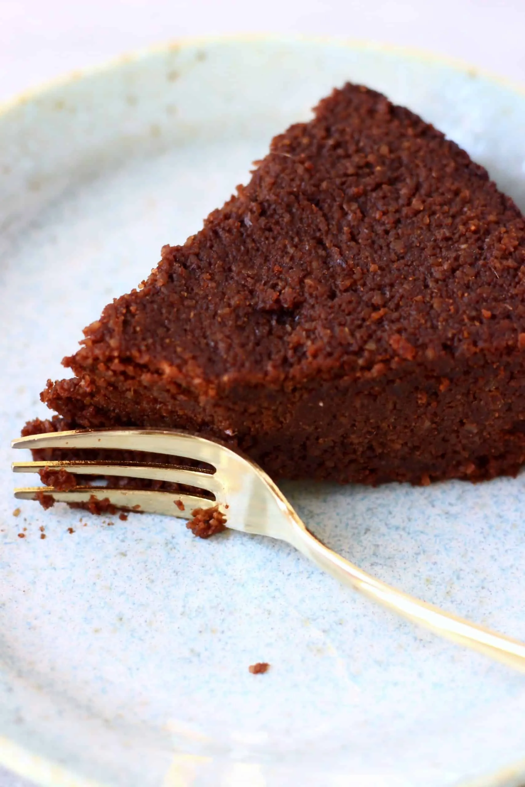 A slice of chocolate torte with a mouthful taken out of it