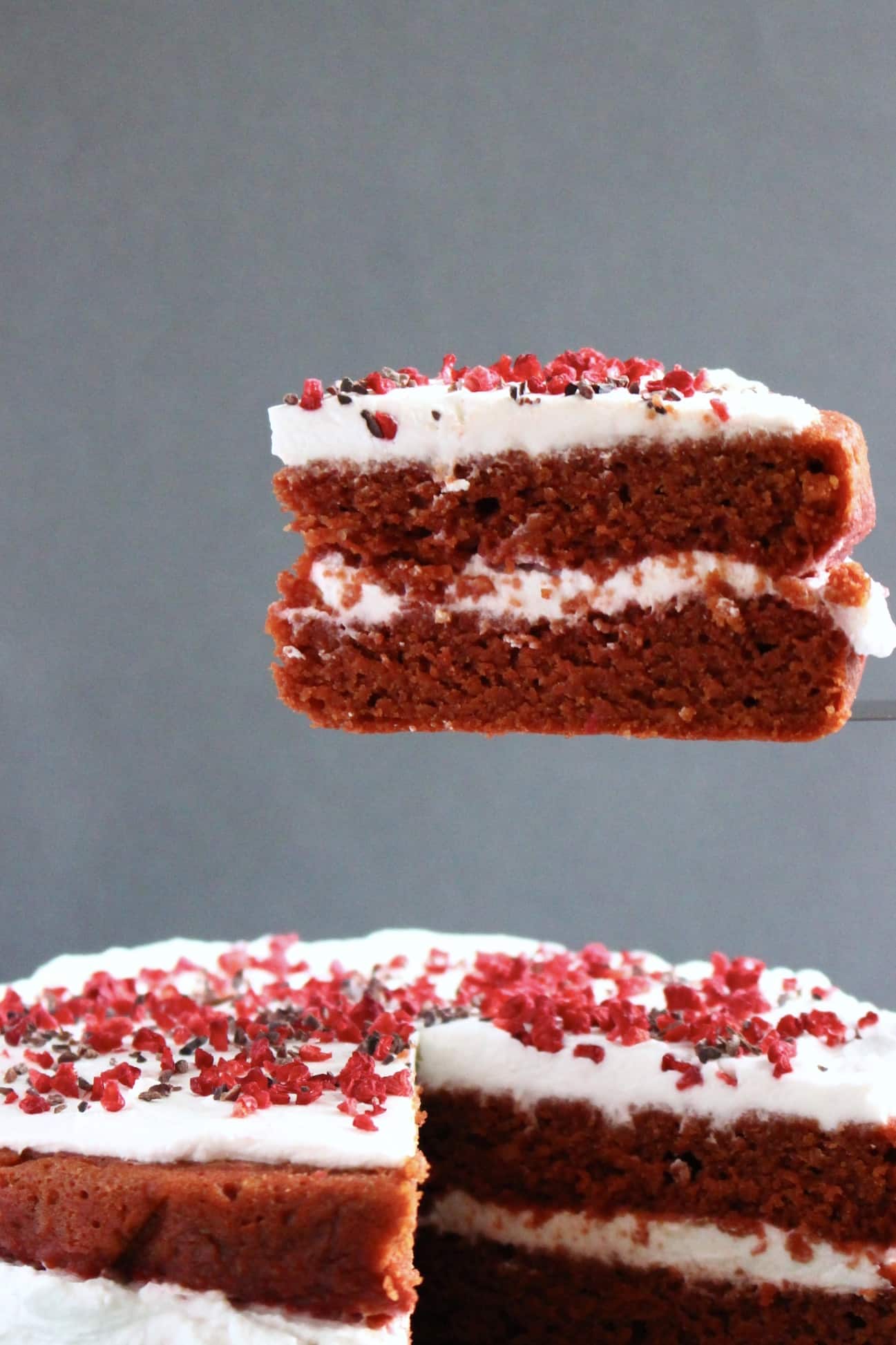 Red velvet cake with a slice being lifted up