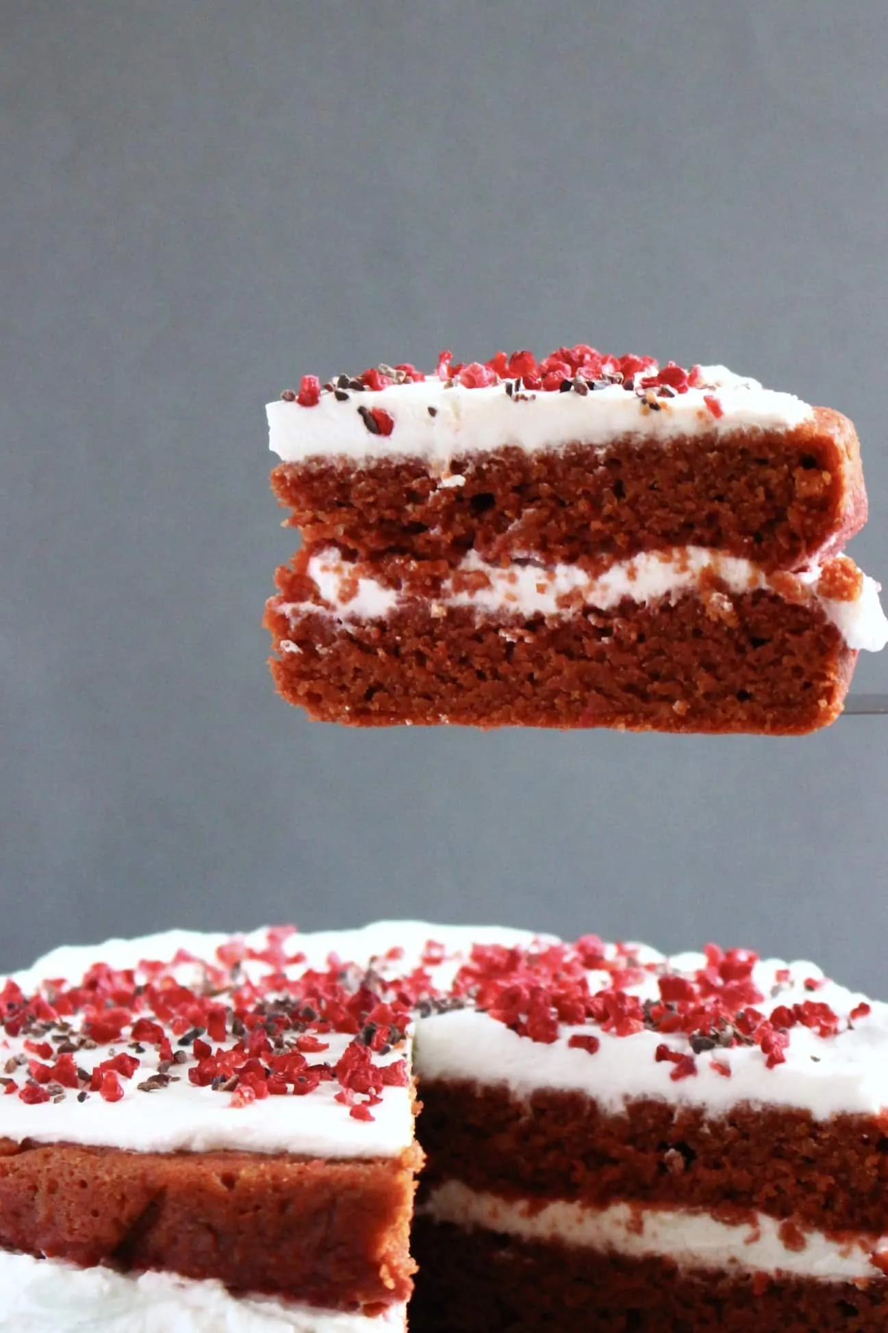 Red velvet cake with a slice being lifted up