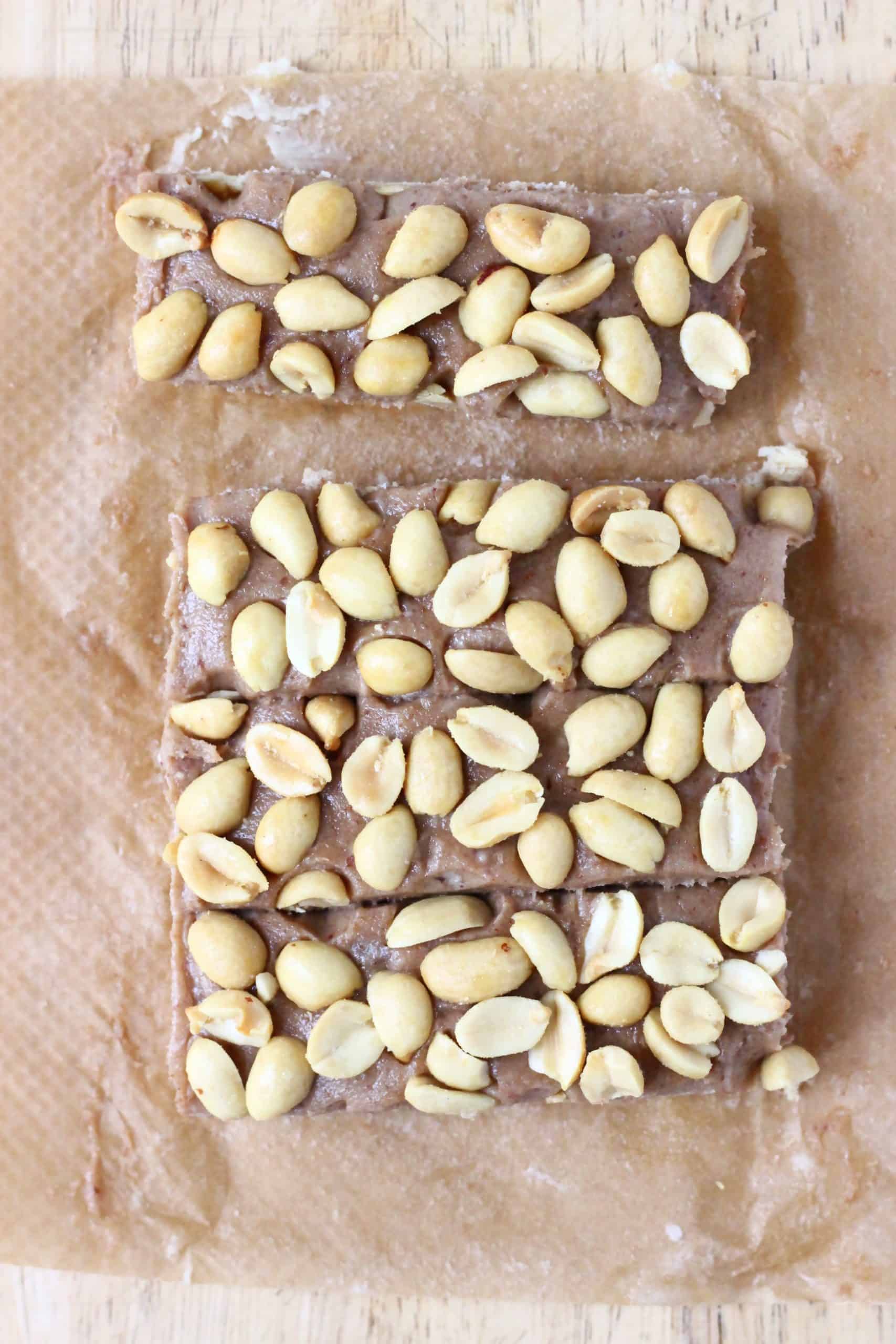 Four vegan snickers bars without chocolate on a sheet of brown baking paper