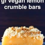 A lemon crumble bar on a marble slab against a brown background