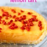 Lemon tart topped with goji berries in a pie dish