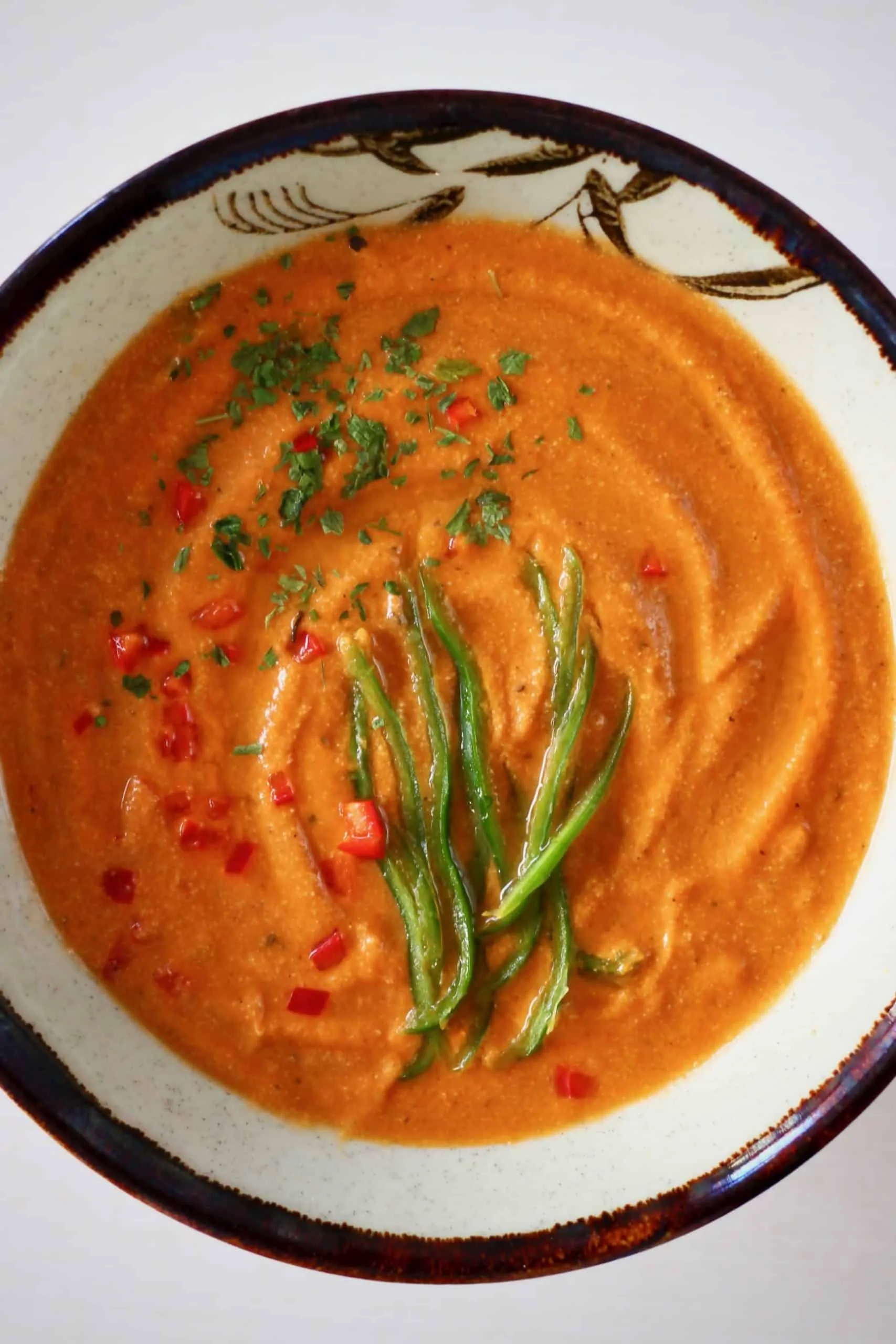 Creamy vegan tomato soup in a brown bowl