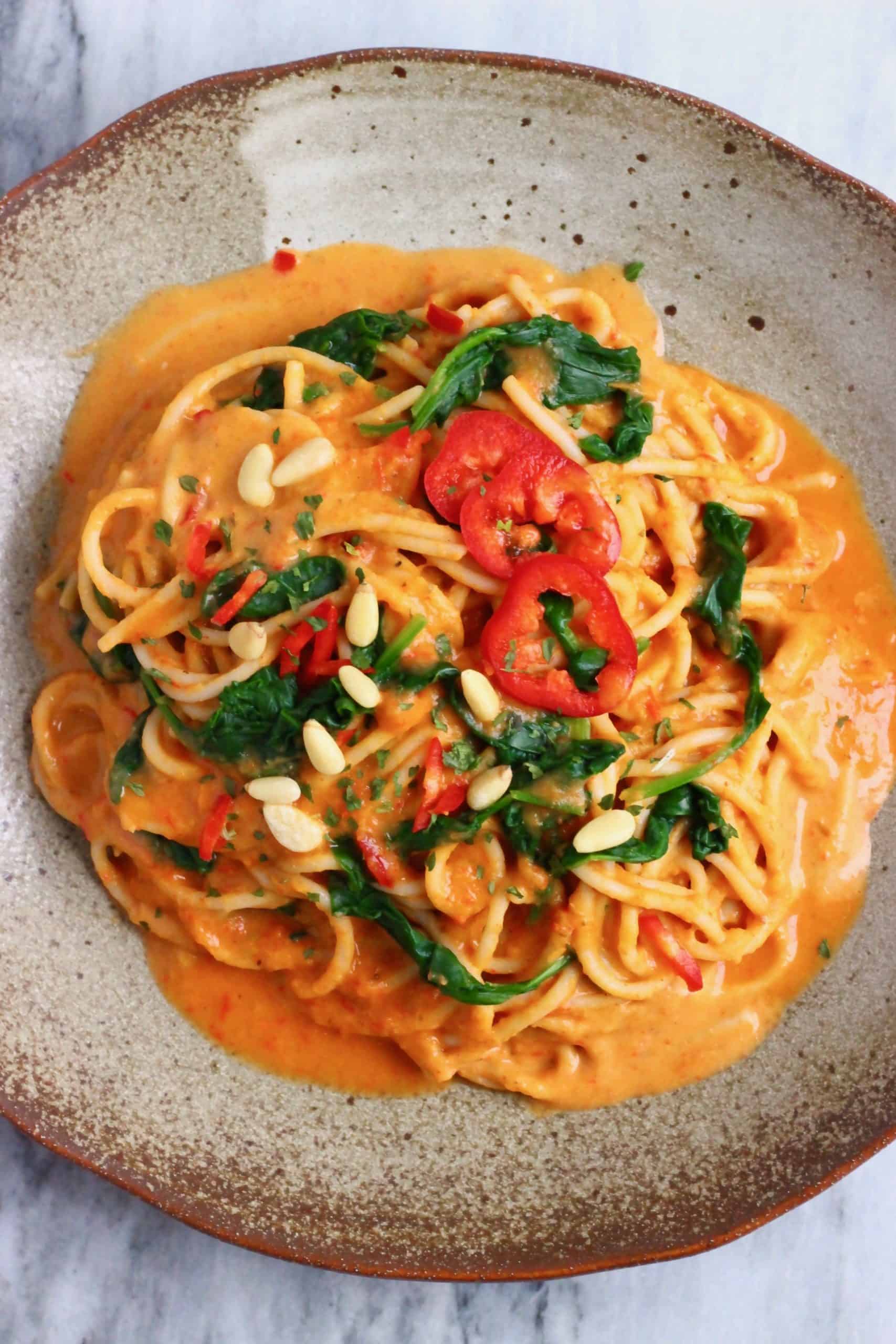 Roasted red pepper pasta sauce with spaghetti on a brown plate